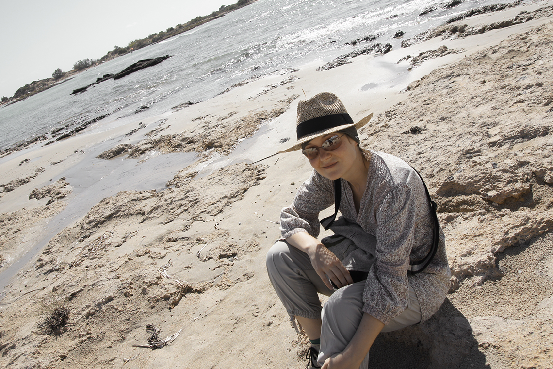 Foto von Marion Lindert, an einem Strand, mit Sonnenhut und Sonnenbrille